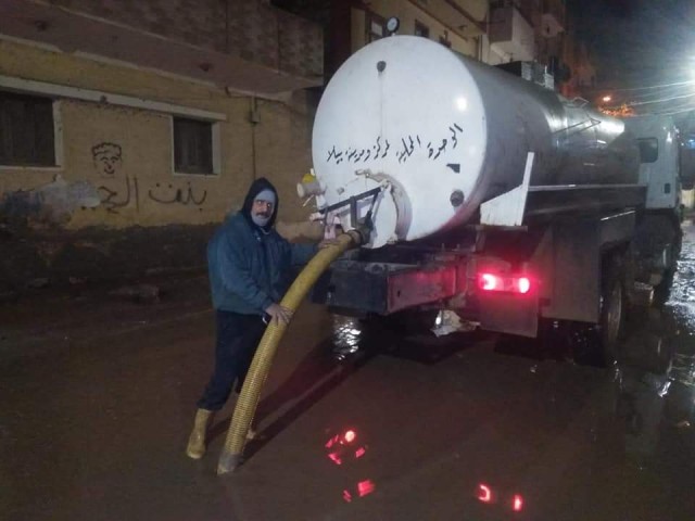 عمال النظافة يواجهون مياه الأمطار بشوارع بيلا في كفر الشيخ